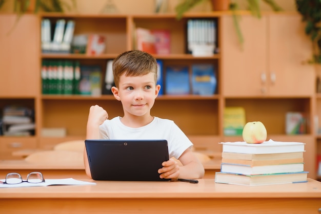 school boy using tablet compute in classroom