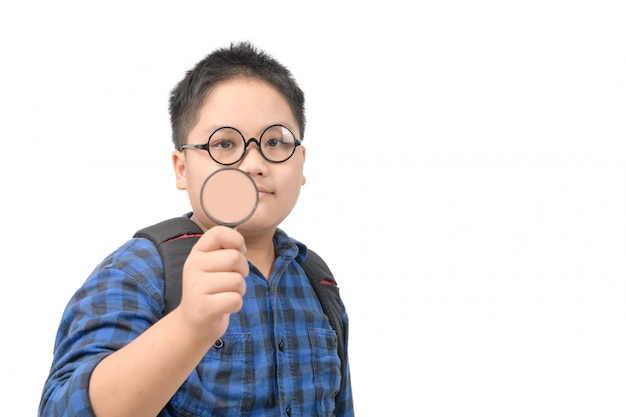 School boy wearing glasses and holding a magnifying glass