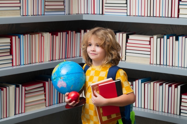 School boy world globe and books Back to school Portrait of cute child school boy Schoolboy and education kids concept Clever kid with school supplies