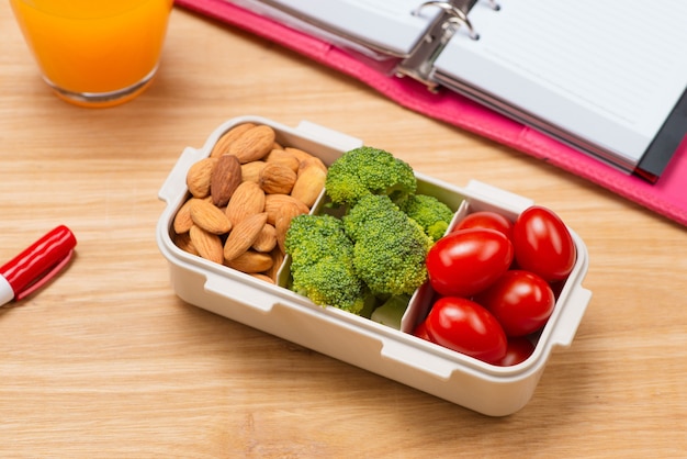 School breakfast on desk with books and pen on board background