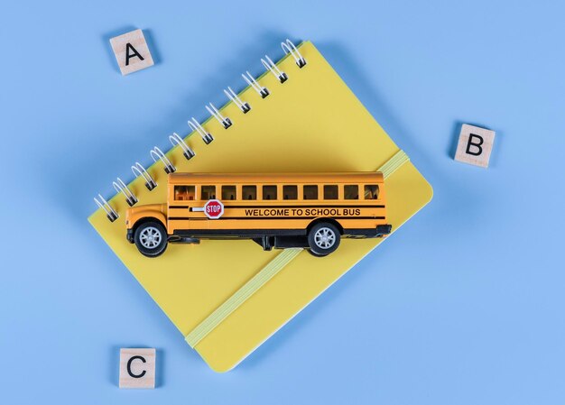 Photo school bus and notebook on blue