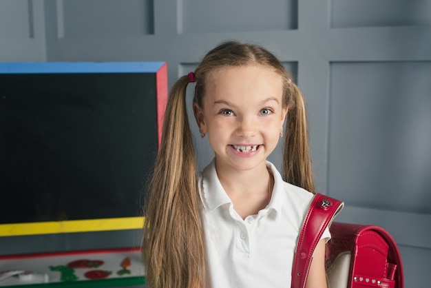 School child in a classroom with blackboard back to school