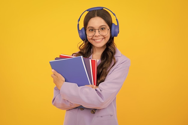 School child girl with headphones and book