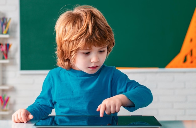 학교 교실에서 태블릿을 가진 학교 아이들이 초등학교부터 아이들을 배우고 있습니다.