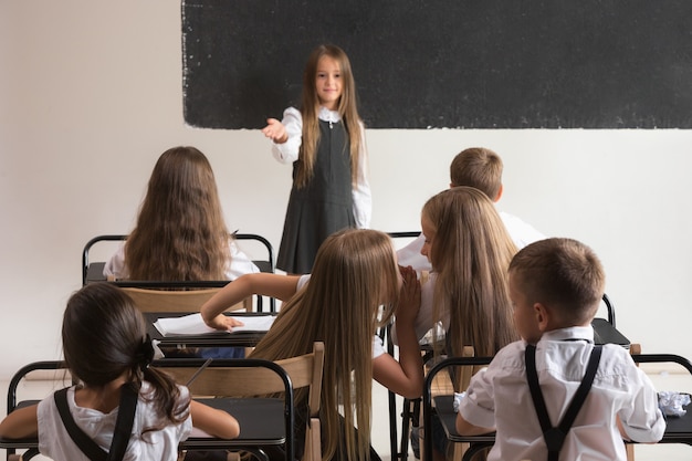 School children in classroom at lesson. The little boys and girls sitting at desks. Back to school, education, classroom, lesson, learn, lifestyle, childhood concept