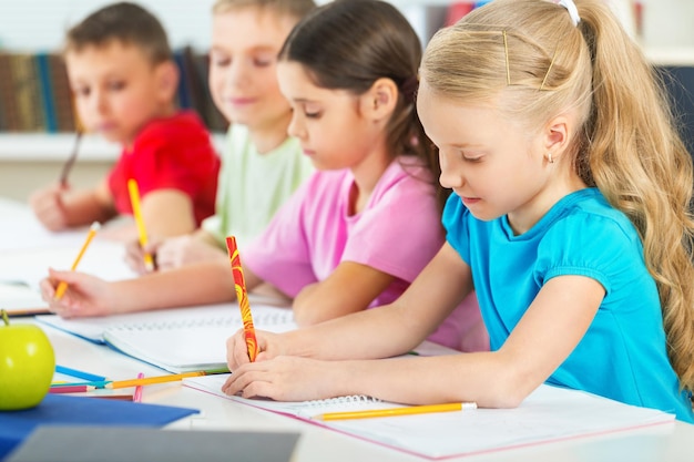 Foto i bambini delle scuole in aula scrivono, disegnano