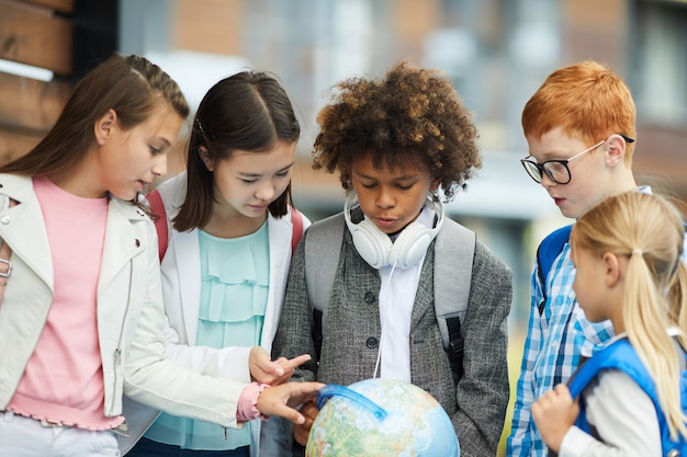 School children examining globe