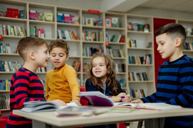 I bambini delle scuole in biblioteca leggono libri, fanno i compiti, preparano un progetto scolastico per le lezioni