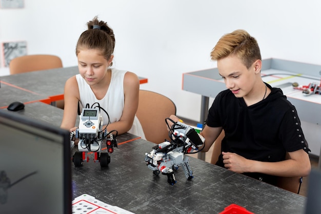 Photo school children programs a robot in the classroom