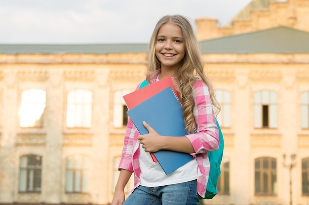 School club Modern education Private schooling Teen with backpack Stylish smiling schoolgirl Girl little fashionable schoolgirl carry backpack school building background Schoolgirl daily life