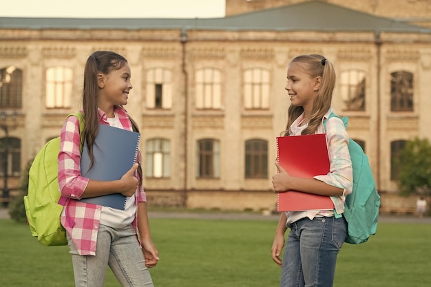 学校クラブ 現代教育 私立学校 バックパックを背負った十代の若者たち スタイリッシュな笑顔の女子学生 女子校舎の背景 夏の学校なしで子供たちが追いつくか、前進するのを助ける