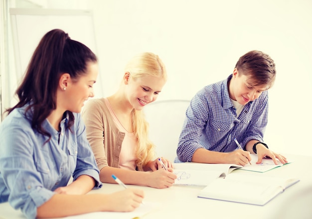 Photo school and education concept - group of smiling students with notebooks at school