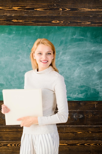 Photo school education job educational theme smiling teacher in classroom teacher with book portrait of