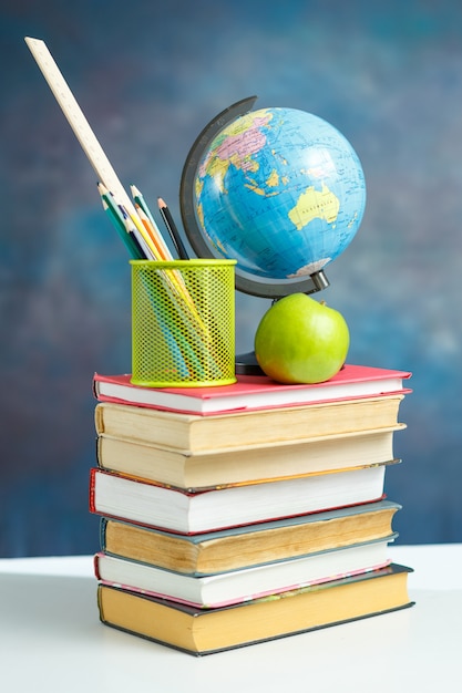 Elementi di scuola con libri e terra del globo