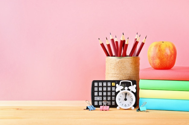 School en kantoorbenodigdheden op een roze achtergrond. Terug naar school.