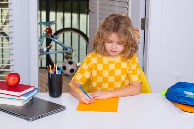 School en onderwijs concept portret van schattig kind schooljongen zitten aan de tafel schrijven school h