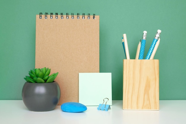 School equipment on white table green wall background Education Wooden supplies Back to school Desk