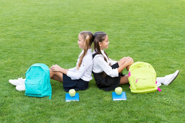 School friends relaxing after classes at school yard, hard day concept.