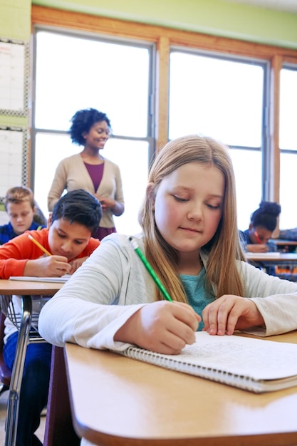 写真 女子高生と本教育での書き込みとテスト試験の勉強と教室での学習 教師の女子学生とノートを持つ学習者 フォーカスとメモと集中力の思考