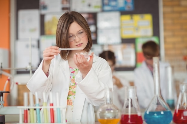 Foto ragazza della scuola che sperimenta con la sostanza chimica in laboratorio a scuola