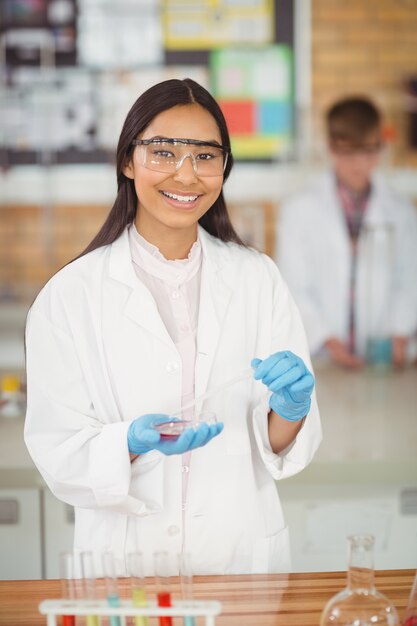 Photo school girl experimenting with chemical in laboratory at school