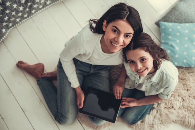 School girl and her mom using a digital tablet.