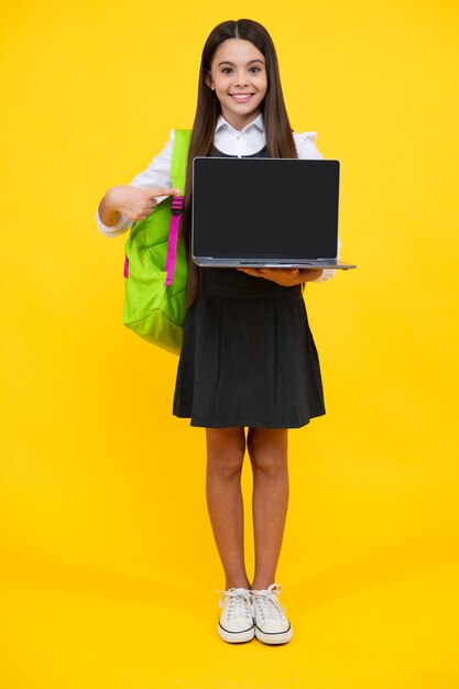 School girl hold laptop notebook on isolated studio background schooling and education concept