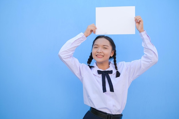 School girl holding billboard on blue background