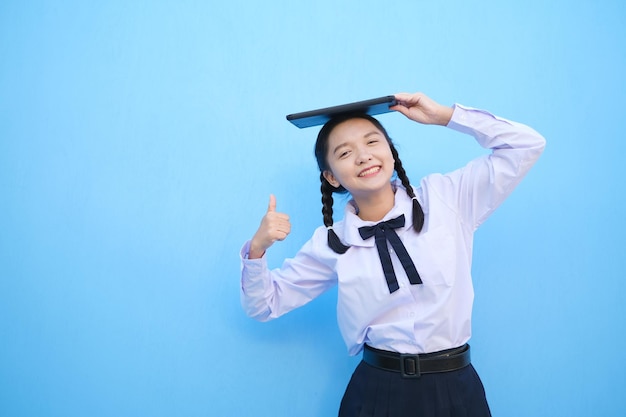 School girl holding tablet on blue background