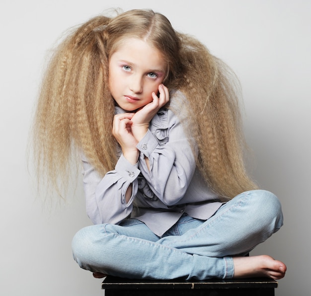 School girl posing sitting on a chair