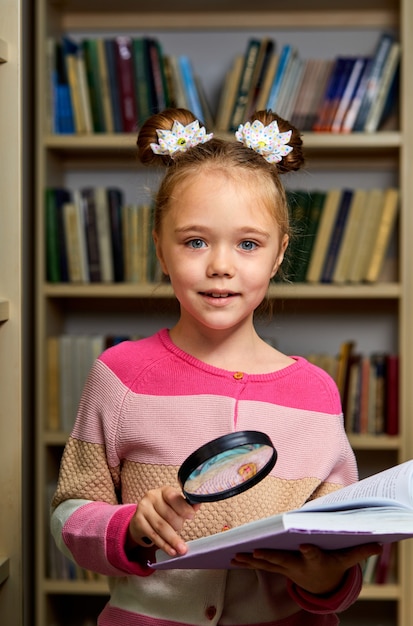 Photo school girl standing with encyclopedia in library, reading a book, get new information for brain