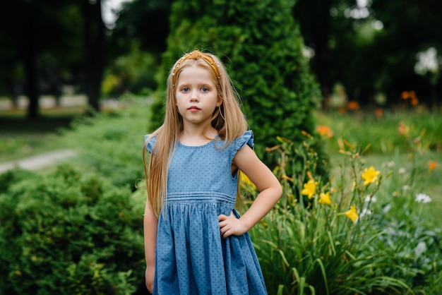 A school girl stands and smiles in an outdoor Park