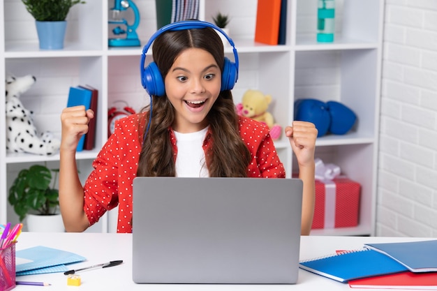 School girl student sitting at the table using laptop when studying Happy girl face positive