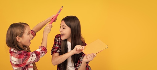 School girls friends cheerful children in casual checkered shirt having fun notebooks best friend