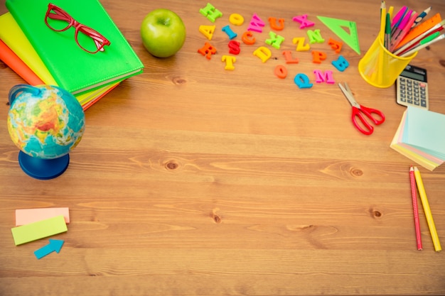 School items on wooden desk in class. Education concept. Top view