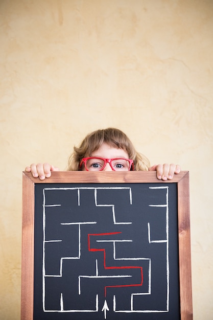 Photo school kid in class. happy child holding blackboard blank. education concept