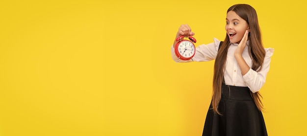 Photo school kid in uniform showing time you are late deadline good morning punctuality last chance teenager child with clock alarm horizontal poster banner header copy space