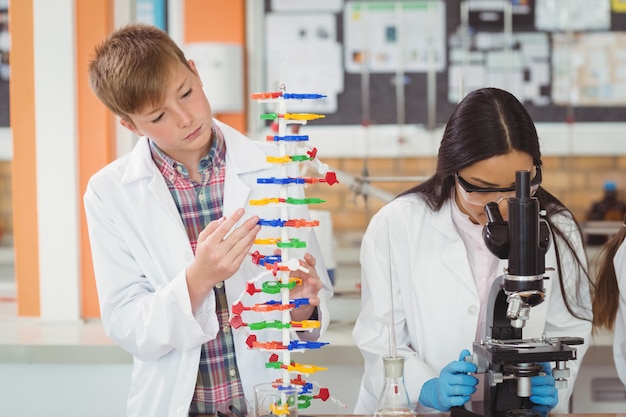 School kids experimenting molecule model in laboratory