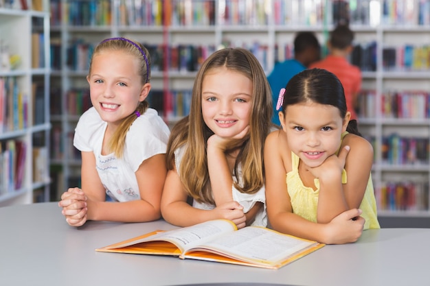 学校の子供たちが図書館で一緒に本を読んで