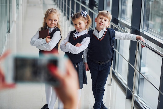 School kids in uniform making a photo together in corridor Conception of education