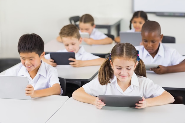 Bambini della scuola che utilizzano compressa digitale nell'aula