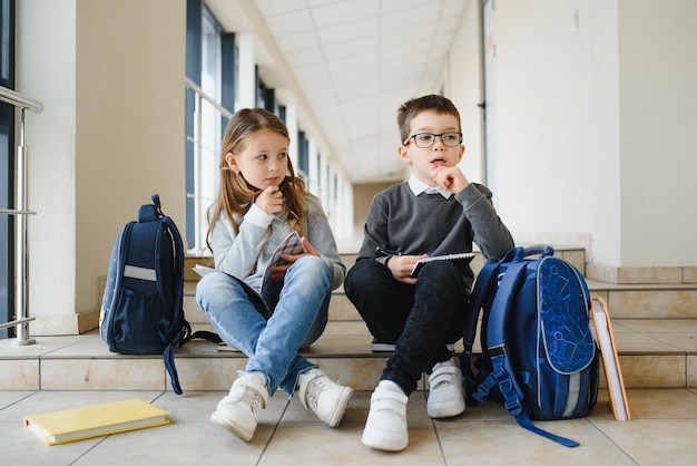 写真 廊下で一緒に本を持っている学校の子供たち教育の概念