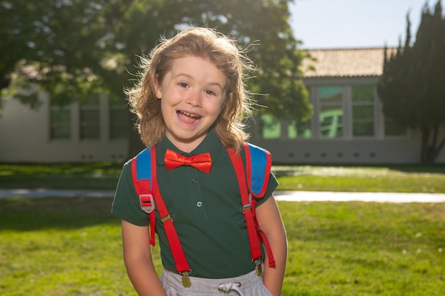 School kind concept schattig leerling kind in schooluniform met rugzak buiten portret van nerd schooljongen