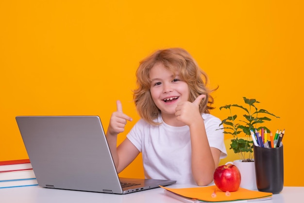 School kind laptopcomputer gebruikt Terug naar school Grappige kleine jongen van de basisschool met boek