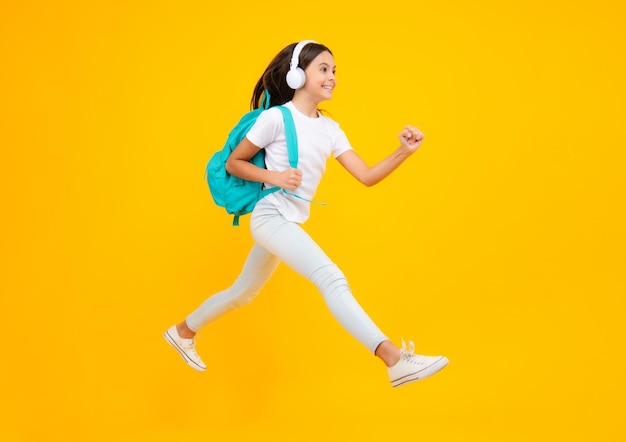 School leisure Happy teenager portrait School girl in headphones on isolated studio background