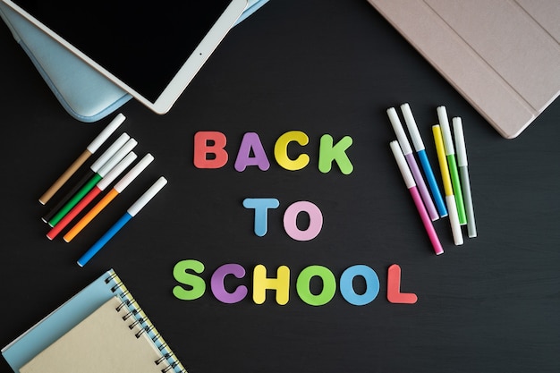 School materials with the phrase BACK TO SCHOOL on a black background. 