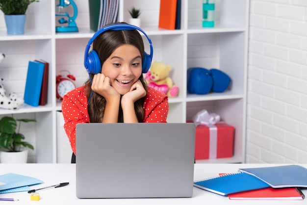 School meisje student zittend aan de tafel met behulp van laptop tijdens het studeren Happy girl face positive