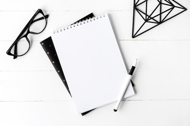 School notebook with glasses and coffee on a wooden background