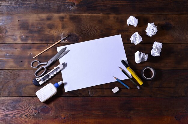 Photo a school or office still life with a white blank sheet of paper and many office supplies.