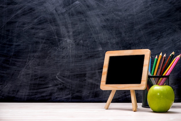 黒板の前にある学用品や事務用品、リンゴ。